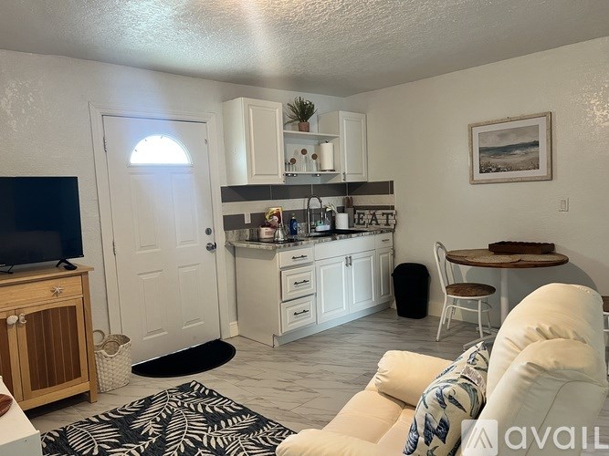 A living room with a white couch and a black and white rug.