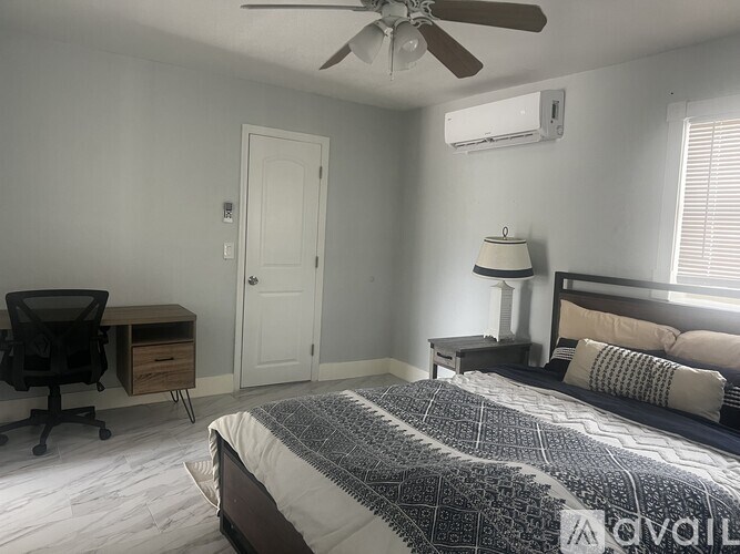 A bedroom with a bed, desk, and chair.