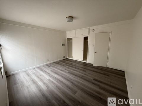 A bedroom with a bed, a dresser, and a window with blinds.