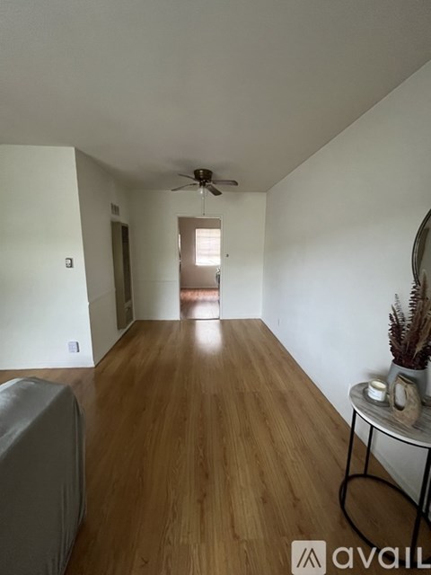 A room with wooden floors and a ceiling fan.