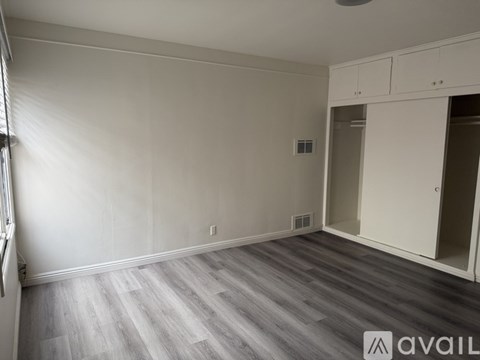 A bedroom with a bed, chair, and television.