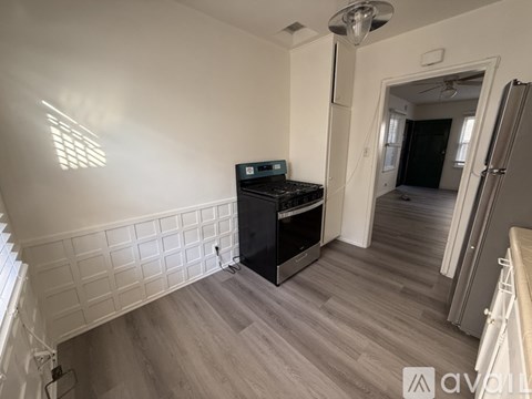 A kitchen with a stove and a window with blinds.