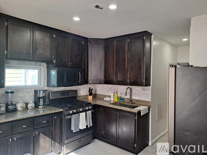 A kitchen with black cabinets and a stove top oven.