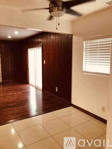 A room with wooden walls and a ceiling fan.