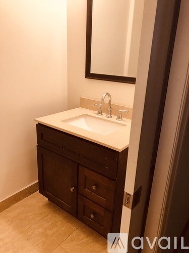 A bathroom sink with a mirror above it and a cabinet below.