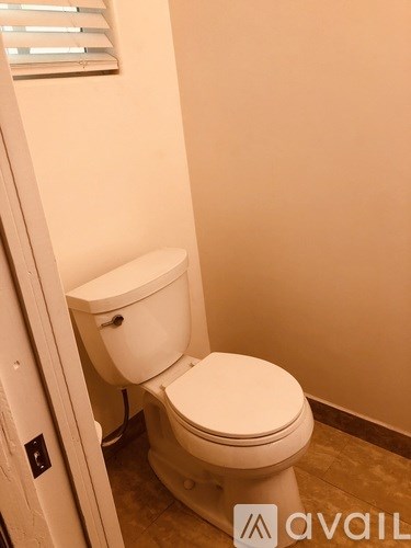 A white toilet in a bathroom with a closed lid.