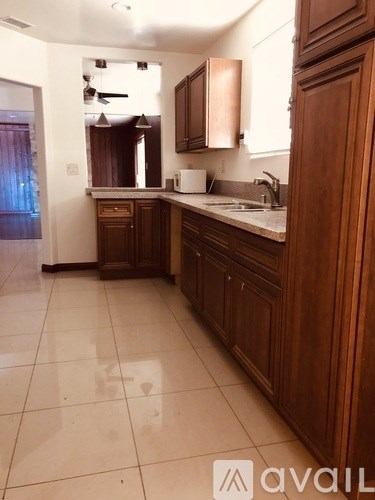 A kitchen with wooden cabinets and a white counter.