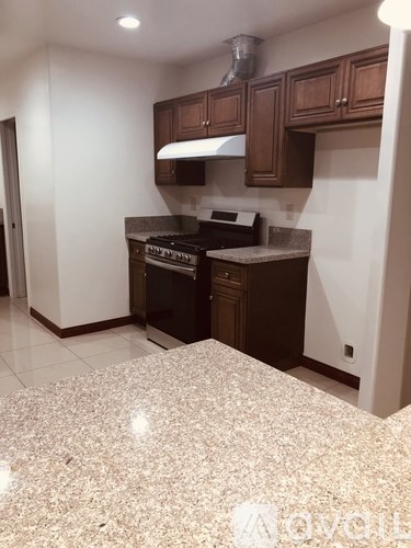 A kitchen with brown cabinets and a granite countertop.