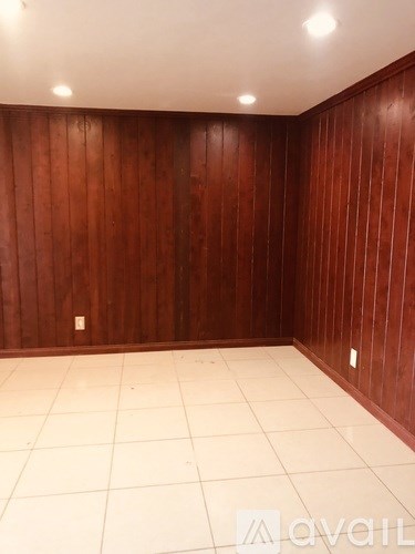 A room with wooden walls and white tiled floor.