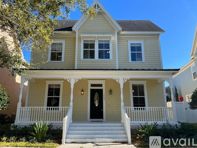 A two-story house with a front porch and a black door.