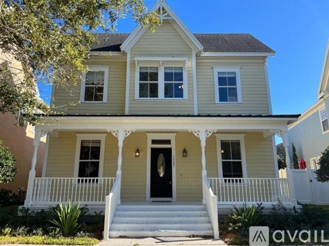 A two-story house with a front porch and a black door.