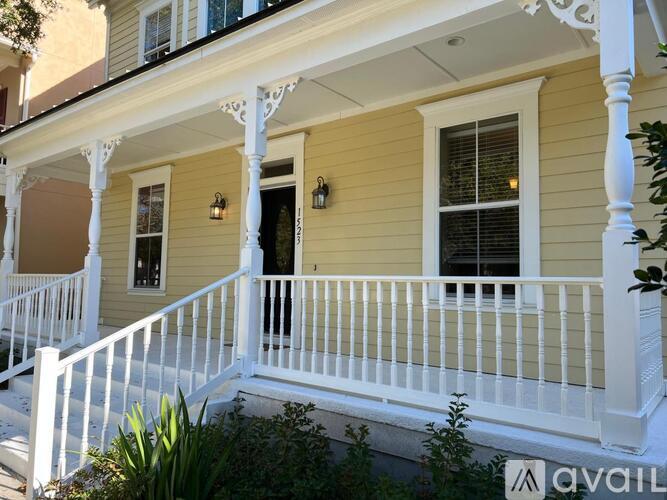A yellow house with white railings and a balcony.