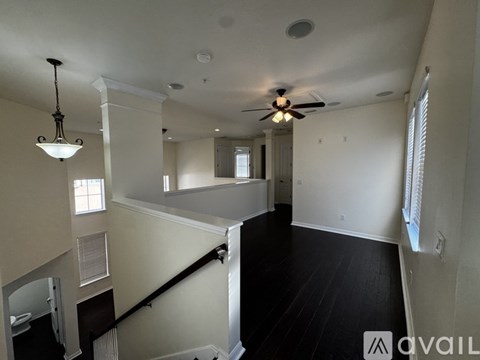 A spacious room with a staircase leading to the second floor.