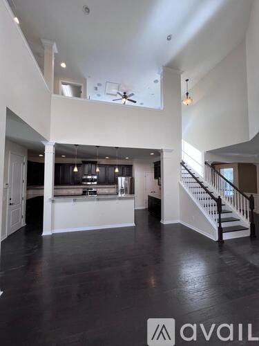 A spacious living room with a staircase leading to the upper level.