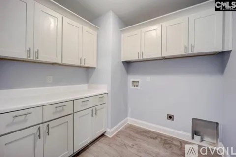 A kitchen with white cabinets and a countertop.