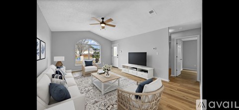 A living room with a white couch and a television.