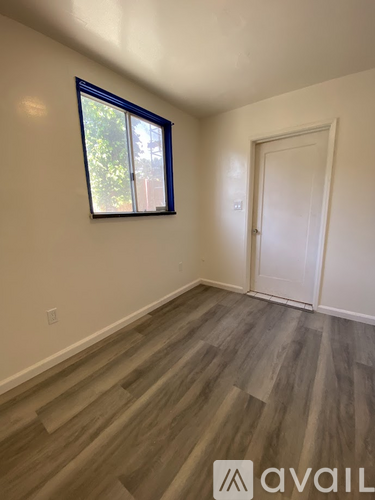 A room with a window and wooden flooring.
