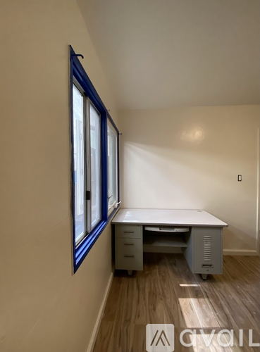 A corner desk with a window and a white wall.