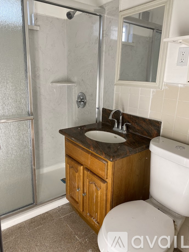 A bathroom with a toilet, sink, and shower.