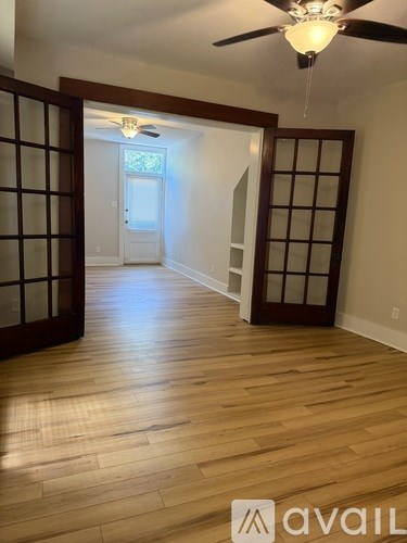 A room with wooden floors and a ceiling fan.