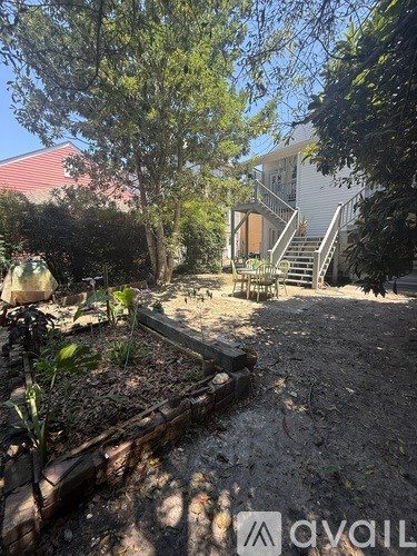 A backyard with a wooden deck and a garden bed.
