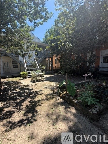 A backyard with a patio and a tree.