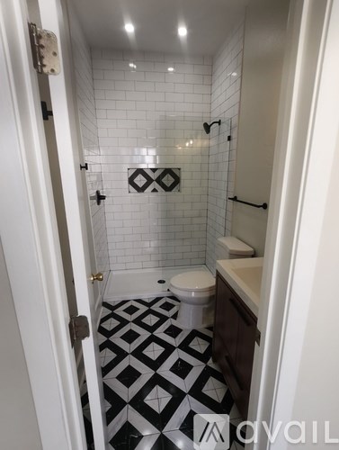 A bathroom with a black and white tiled floor.