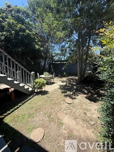 A backyard with a white deck and a tree.