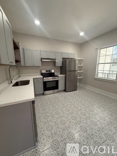 A kitchen with a patterned floor and a window.