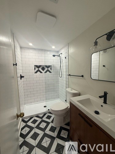 A bathroom with a black and white tiled floor.