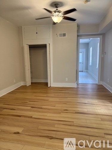 A room with wooden flooring and a ceiling fan.
