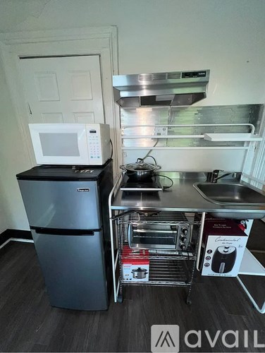 A kitchen with a microwave on top of a fridge and a dishwasher.