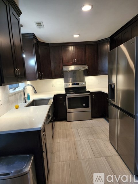 A kitchen with dark wood cabinets and stainless steel appliances.