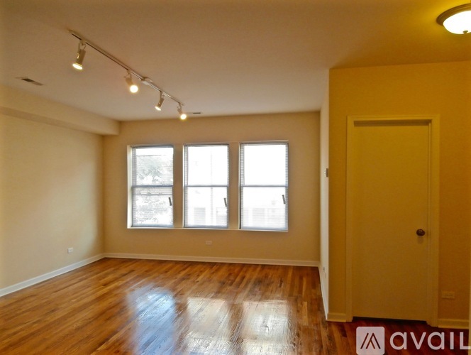 A room with wooden floors and a yellow door.