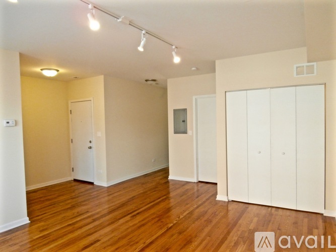 A spacious room with wooden floors and white walls.