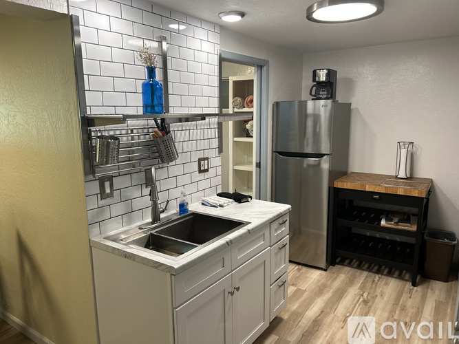 A kitchen with a stainless steel refrigerator and a wooden cutting board.