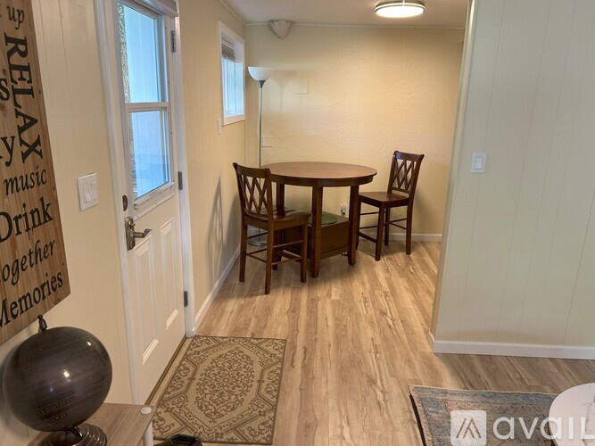 A dining room with a wooden table and chairs.