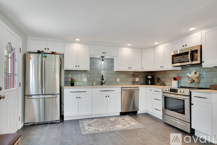 A kitchen with white cabinets and stainless steel appliances.