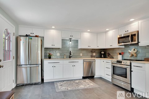 A kitchen with white cabinets and stainless steel appliances.