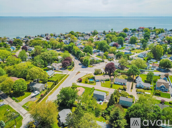 A bird's eye view of a residential area with houses, trees, and a road.