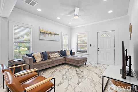 A living room with a brown leather chair and a grey couch with pillows.