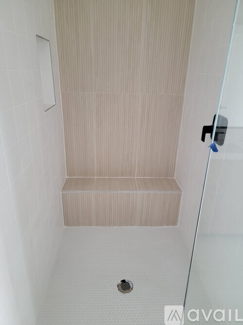 A bathroom with a shower and a drain.