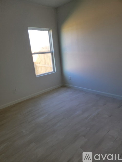 A room with a window and wooden flooring.