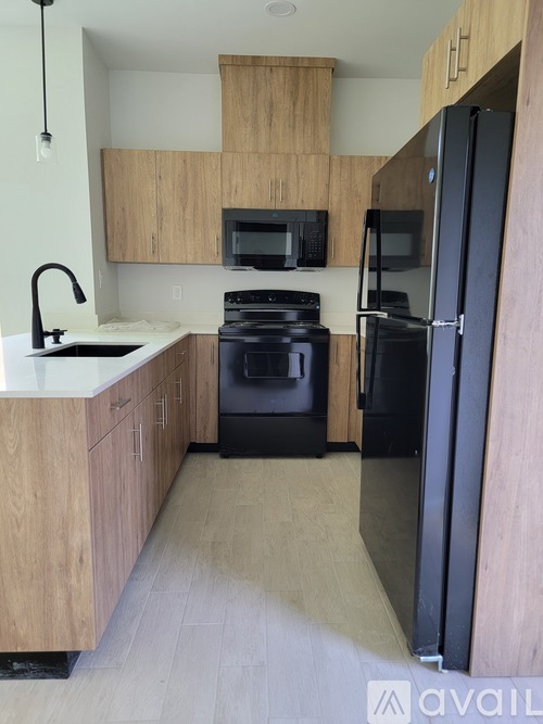 A kitchen with a black refrigerator and stove.