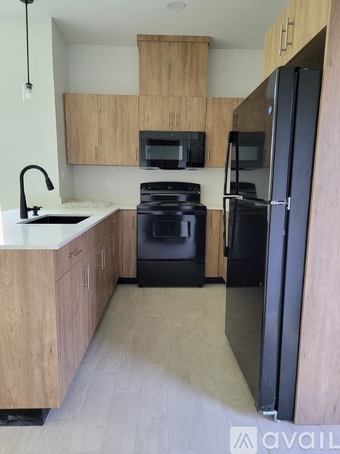 A kitchen with a black refrigerator and stove.