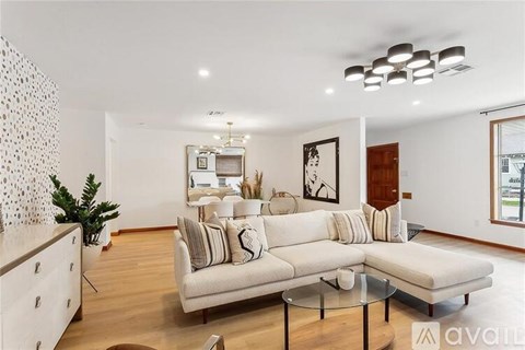 A living room with a white couch and a glass table.