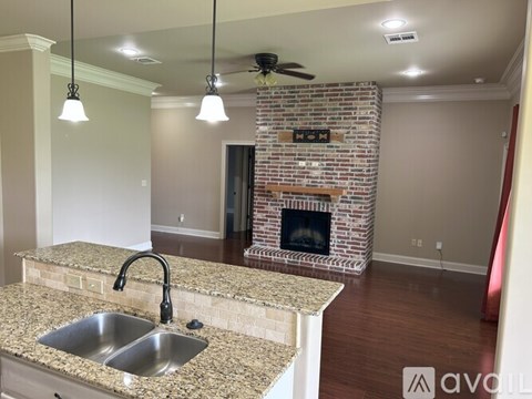 A kitchen with a stone countertop and a brick fireplace.