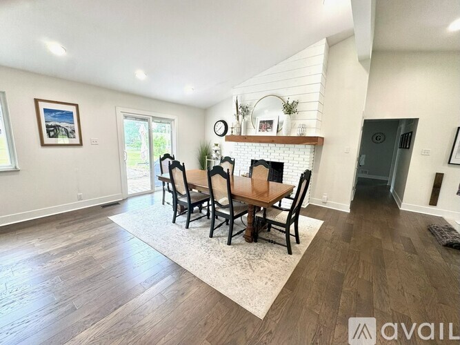 A dining room with a fireplace and a rug in front of it.