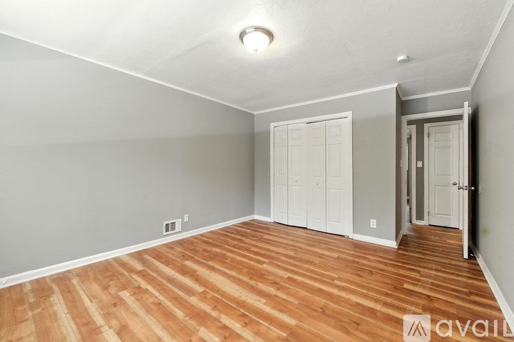 A room with wooden flooring and white walls.