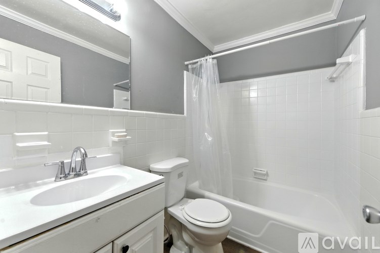 A white bathroom with a sink, toilet, and bathtub.